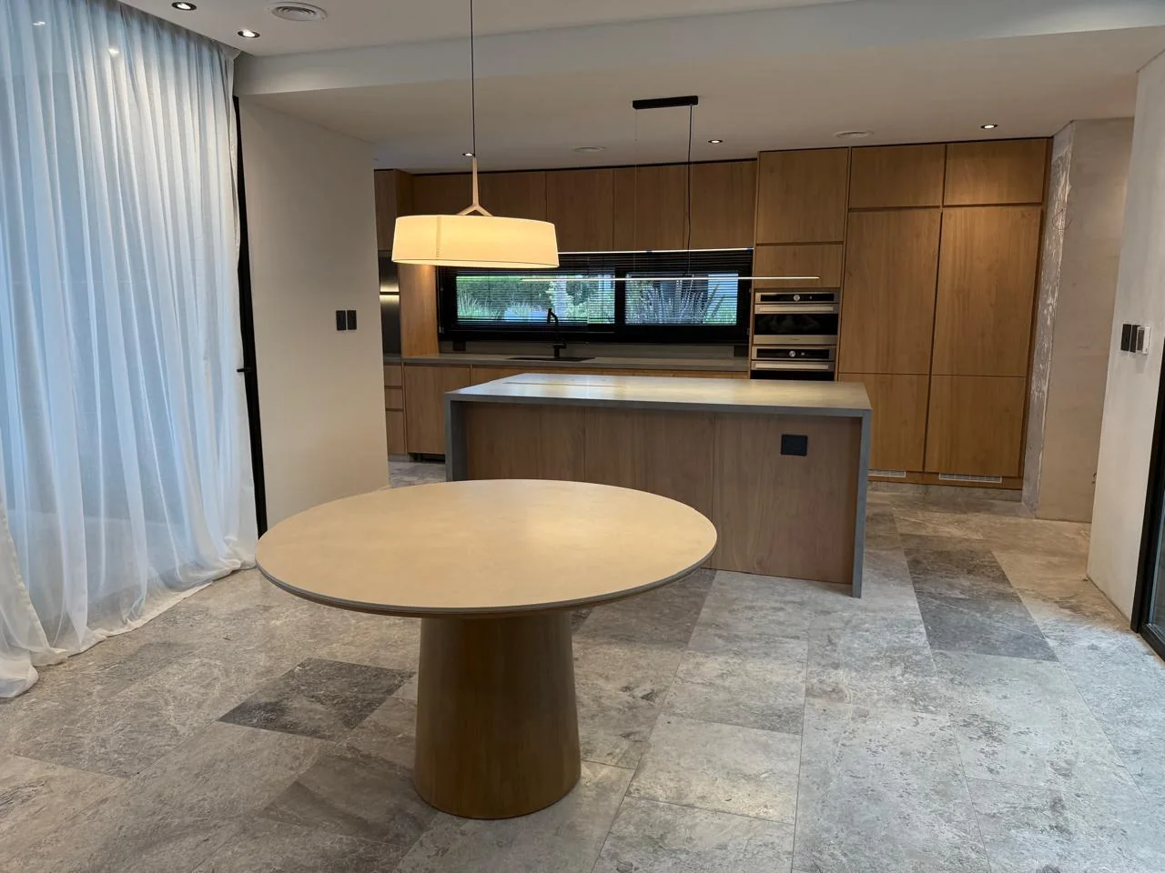 Cocina integral de madera con isla y mesa
