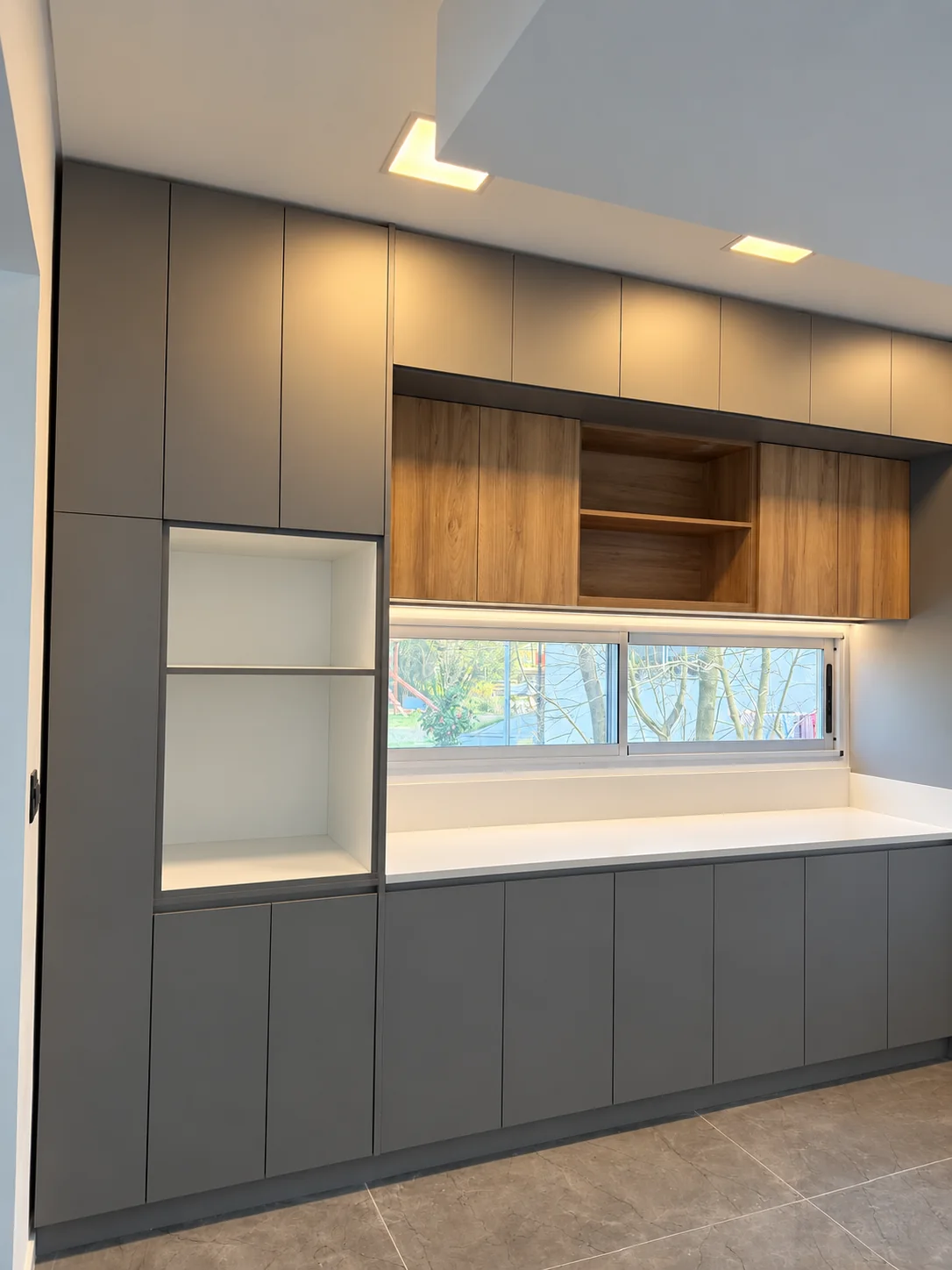 Cocina con mesada blanca de KRION bajo ventana